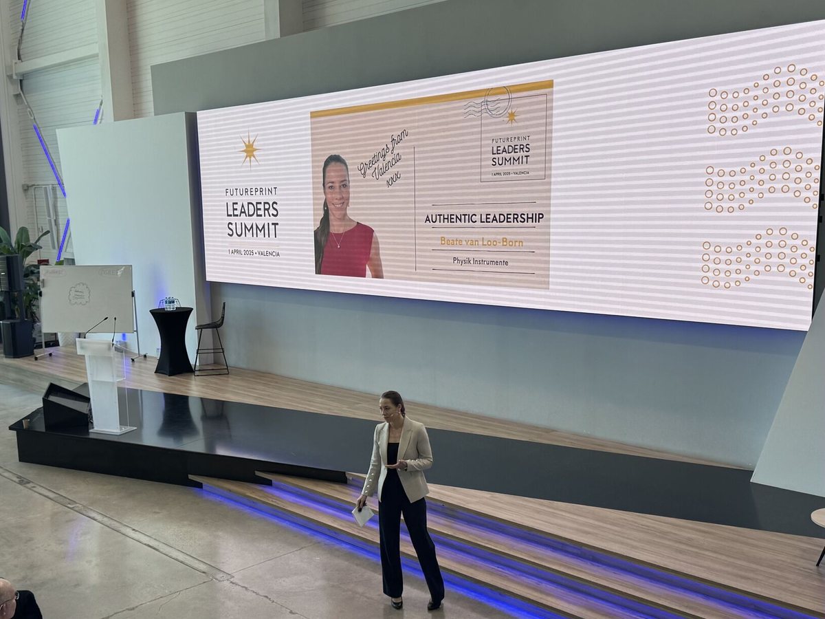 Beate van Loo-Born on stage at the FuturePrint Leaders Summit in Valencia, her keynote title slide on the screen behind her.